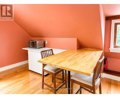 A dining room with a wooden table and chairs.