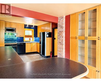 A kitchen with wooden cabinets and a brick wall.