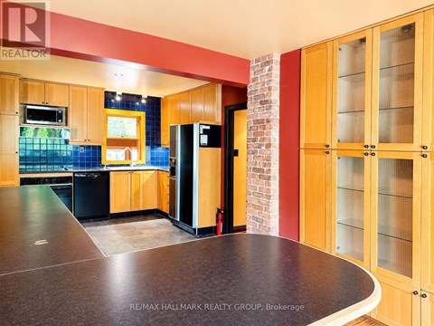 A kitchen with wooden cabinets and a brick wall.