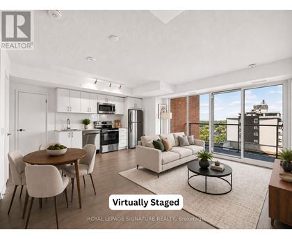 A modern living room with a dining table and chairs, and a kitchen area with appliances.