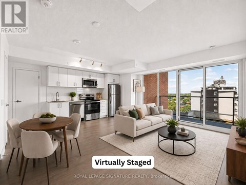 A modern living room with a dining table and chairs, and a kitchen area with appliances.