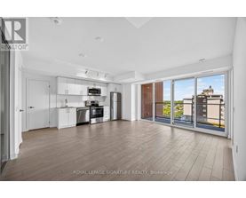 A spacious kitchen with white cabinets and a view of the city.