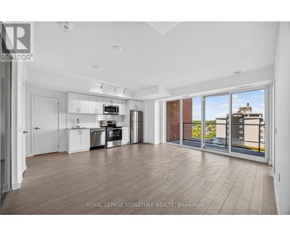 A spacious kitchen with white cabinets and a view of the city.