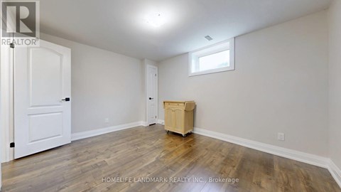 A room with a wooden floor and a white door.