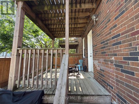 A wooden deck with a brick wall and a doorway.