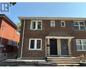 A house with a black door and white windows is for sale.