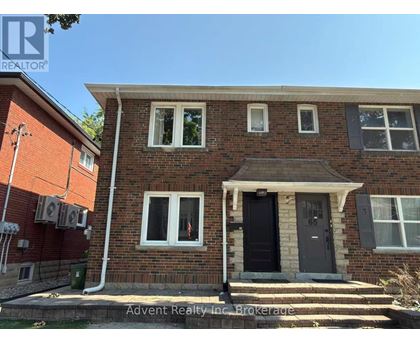 A house with a black door and white windows is for sale.