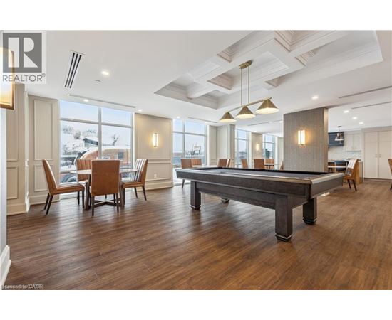 A pool table in a room with wooden floors and a high ceiling.
