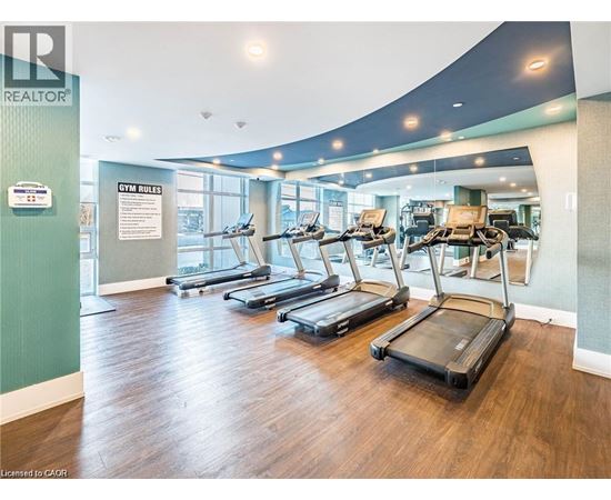 A gym with treadmills and a sign that says "GYM RULES".