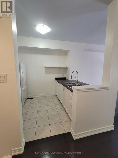 A kitchen with white cabinets and a black counter top.