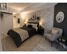 A bedroom with a bed, chair, and wall decor.