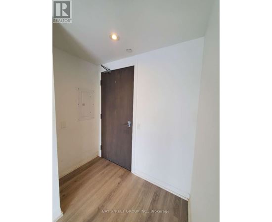 A room with a wooden floor and a brown door.