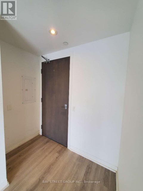 A room with a wooden floor and a brown door.