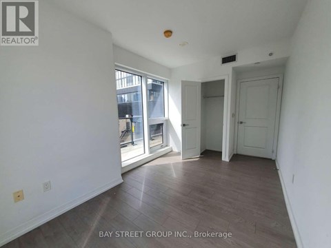 A room with a sliding glass door leading to a balcony.