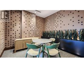 A conference room with a table and chairs and a wall with holes.