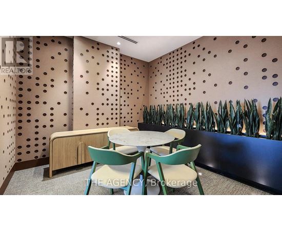 A conference room with a table and chairs and a wall with holes.
