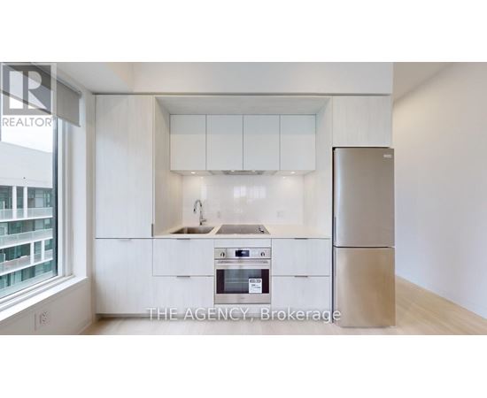 A kitchen with white cabinets and a refrigerator.