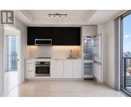 A modern kitchen with white cabinets and a black backsplash.