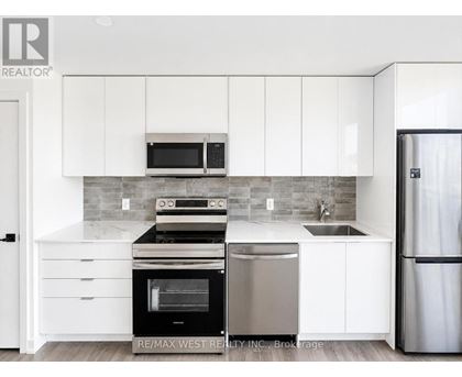 A modern kitchen with white cabinets and stainless steel appliances.