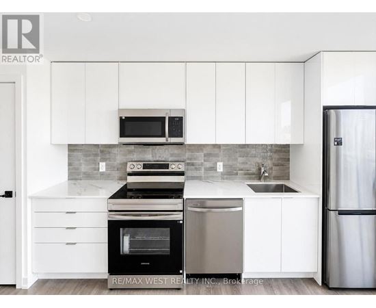 A modern kitchen with white cabinets and stainless steel appliances.