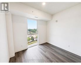 A room with a view of a parking lot through a glass door.