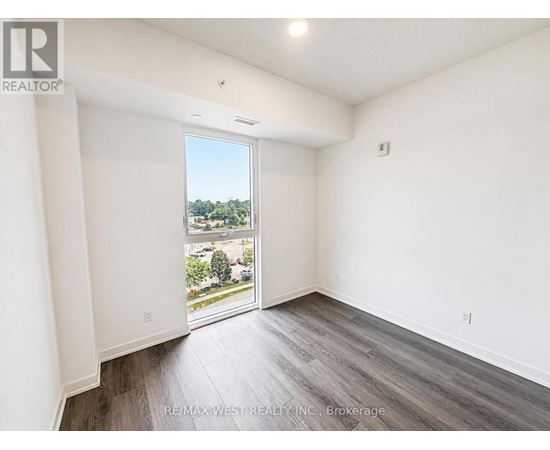 A room with a view of a parking lot through a glass door.