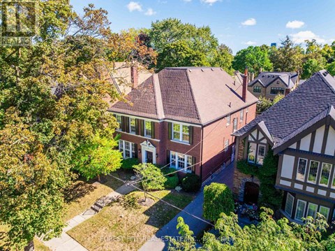 A house with a brown roof is surrounded by trees.