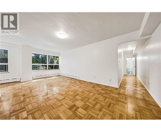 A room with wooden flooring and white walls.