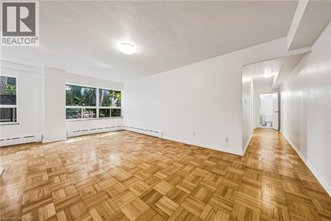 A room with wooden flooring and white walls.