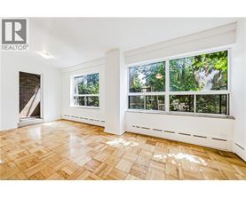 A room with a window overlooking a forest.