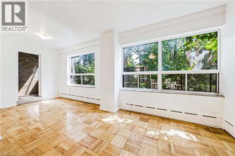 A room with a window overlooking a forest.