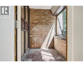A room with a brick wall and a window.