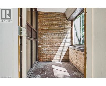 A room with a brick wall and a window.