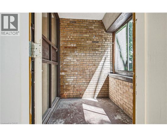 A room with a brick wall and a window.