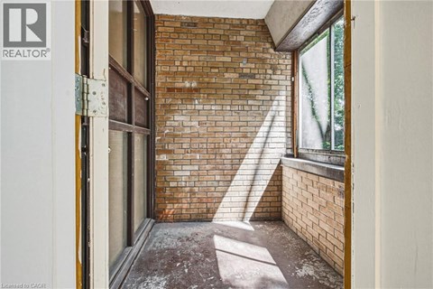 A room with a brick wall and a window.
