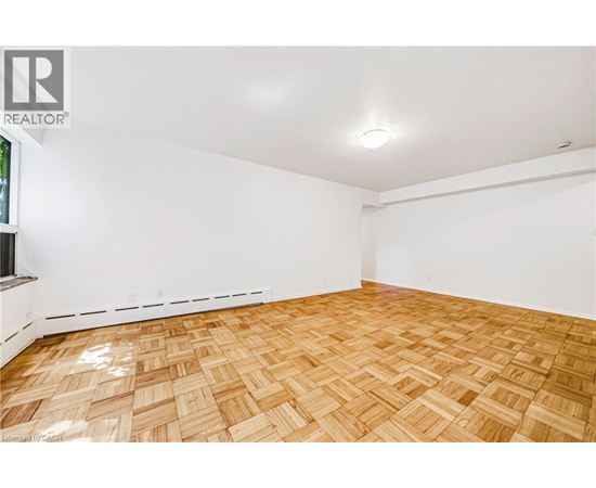 A room with wooden flooring and white walls.