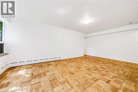 A room with wooden flooring and white walls.