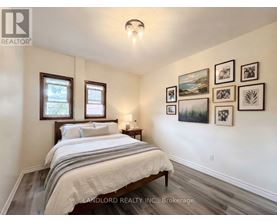 A bedroom with a bed, nightstand, and pictures on the wall.