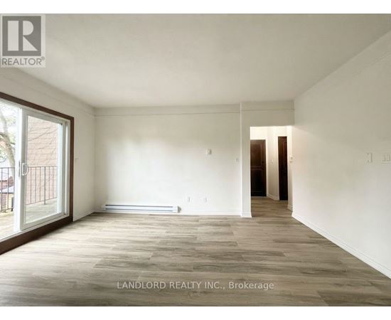 A spacious room with wooden flooring and white walls, part of a property managed by Landlord Realty Inc.