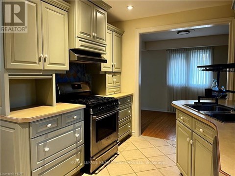 A kitchen with a stove top oven and a sink.