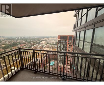 A balcony overlooks a cityscape with buildings and greenery.