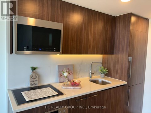 A kitchen with wooden cabinets and a microwave above the counter.