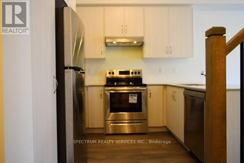 A kitchen with a stove and refrigerator.