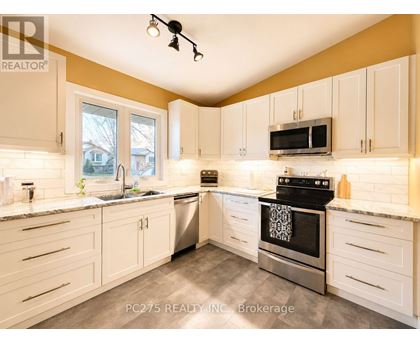 A kitchen with white cabinets and a black stove top oven.
