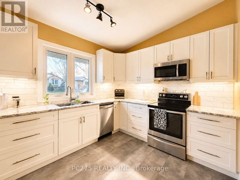 A kitchen with white cabinets and a black stove top oven.