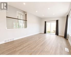 A spacious room with wooden flooring and a sliding glass door leading to a balcony.
