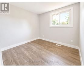 A room with a window and wooden flooring.