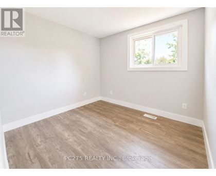 A room with a window and wooden flooring.
