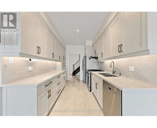 A modern kitchen with white cabinets and a marble countertop.