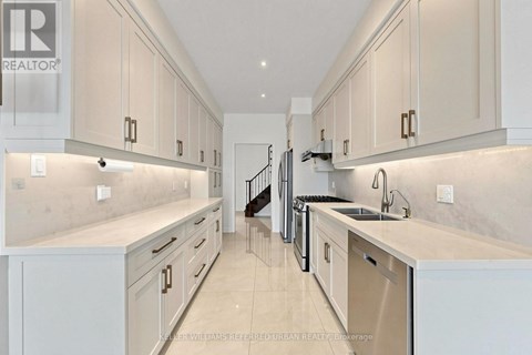 A modern kitchen with white cabinets and a marble countertop.